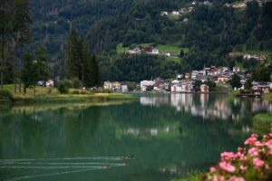 Vue du lac d’Alleghe en Italie du Nord avec village alpin et nature verdoyante